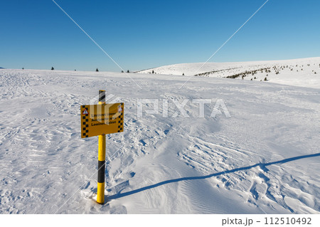 A sign warning of the avalanche area, white elbe valley, krkonose mountains, winter day. A sign warning of the avalanche area, white elbe valley, krkonose mountains, winter day. 112510492