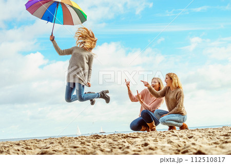 Women jumping with umbrella 112510817