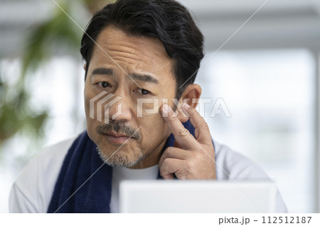 鏡に向かってBBクリームを塗る50代の男性　メンズメイク　イメージ 112512187