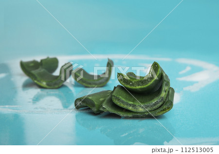 Soap with foam and aloe vera on blue background. Solid shampoo made from natural ingredients 112513005