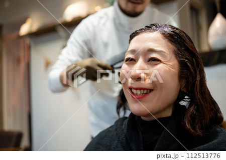 美容室で白髪染めをしてもらう女性 112513776
