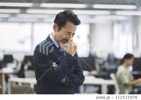 オフィスの中で落ち込むミドルのビジネスマン オフィスの中で落ち込むミドルのビジネスマン 112515976