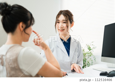 鼻整形の美容外科のカウンセリング・耳鼻科の医師の診察を受ける女性・診療・問診・相談（美容整形） 112516466