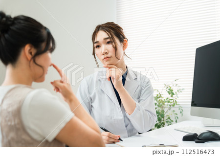 鼻整形の美容外科のカウンセリング・耳鼻科の医師の診察を受ける女性・診療・問診・相談（美容整形） 112516473
