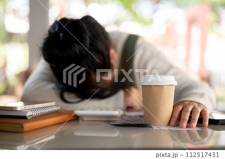 A disappointed and stressed Asian female small business owner is experiencing a financial crisis. 112517431