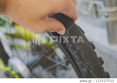自転車のタイヤを指で横から挟み込んでギュッと押してみたら凹んだので空気が甘いと分かった 112517515