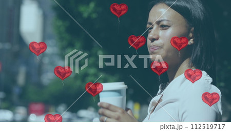 Multiple red heart shapes balloons floating against woman drinking coffee on the street Multiple red heart shapes balloons floating against woman drinking coffee on the street 112519717