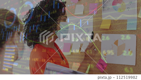 Image of digital interface showing statistics with colleagues in office wearing face masks 112519982