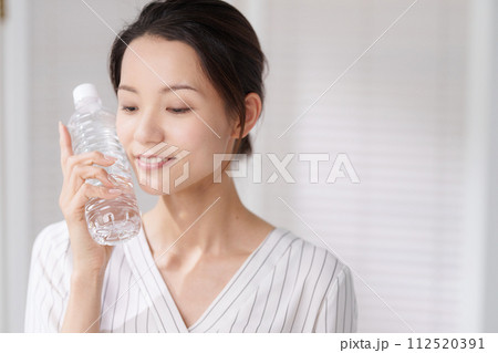 ペットボトルで顔を冷やす女性の写真 ペットボトルで顔を冷やす女性の写真 112520391
