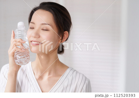 ペットボトルで顔を冷やす女性の写真 112520393