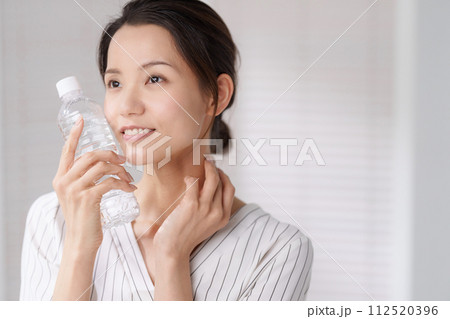 ペットボトルで顔を冷やす女性の写真 ペットボトルで顔を冷やす女性の写真 112520396