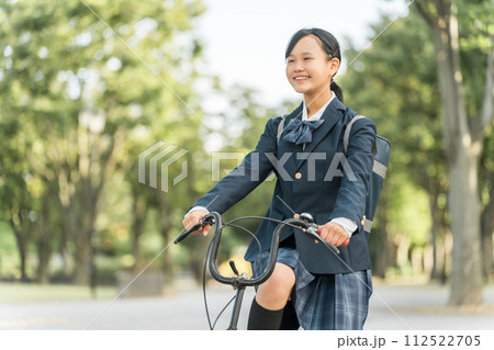 公園の中を自転車通学する制服姿の中学生・高校生の女の子 112522705