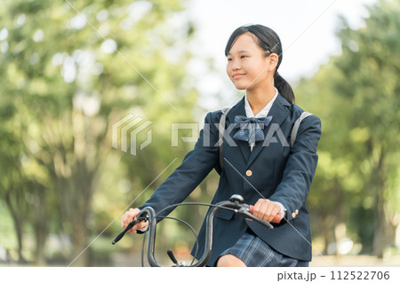 公園の中を自転車通学する制服姿の中学生・高校生の女の子 公園の中を自転車通学する制服姿の中学生・高校生の女の子 112522706