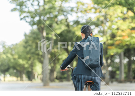 公園の中を自転車通学する制服姿の中学生・高校生の女の子 112522711