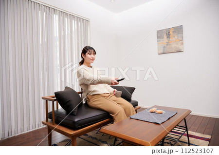 テレビのリモコンを操作する女性 テレビのリモコンを操作する女性 112523107