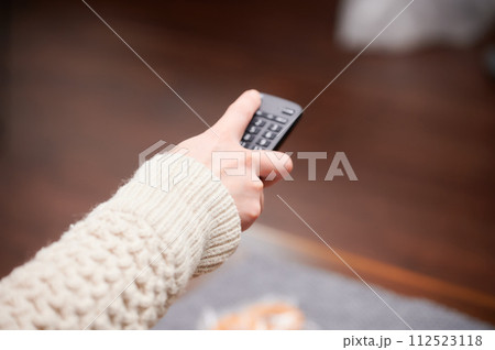 テレビのリモコンを操作する女性 112523118