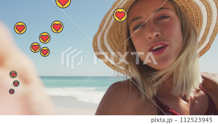 Image of social media heart icons over portrait of smiling woman on beach Image of social media heart icons over portrait of smiling woman on beach 112523945