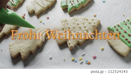 Frohe weihnachten text in orange over decorated christmas cookies on white background Frohe weihnachten text in orange over decorated christmas cookies on white background 112524143