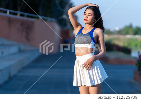 Portrait of beautiful athletic young asian woman in fashionable sportswear standing and having rest after strong exercise training in garden the park,Outdoor Sporty concept 112525739