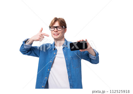 young cheerful red-haired guy dressed in a blue shirt over a t-shirt young cheerful red-haired guy dressed in a blue shirt over a t-shirt 112525918