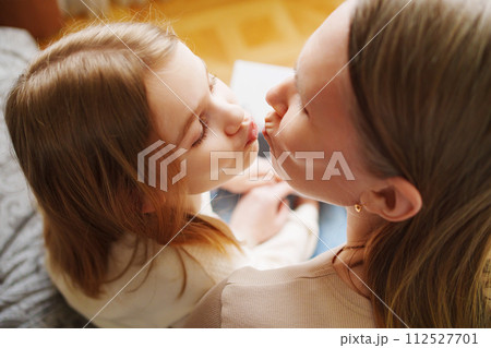 mother and daughter flips through a book with photos of dad and pregnant mom. 112527701