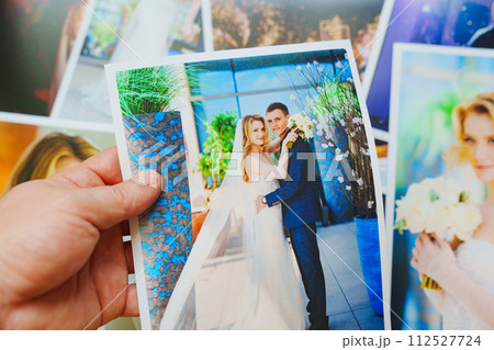 men's hands lay out Beautiful printed wedding photos. Professional photography. 112527724