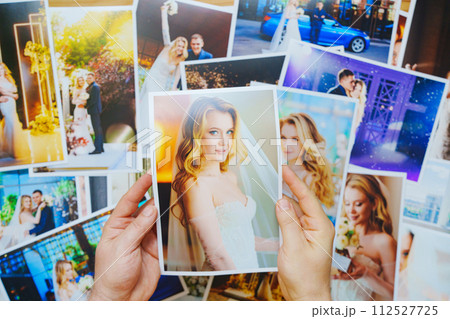 men's hands lay out Beautiful printed wedding photos. Professional photography. 112527725