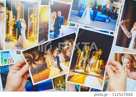 men's hands lay out Beautiful printed wedding photos. Professional photography. men's hands lay out Beautiful printed wedding photos. Professional photography. 112527888