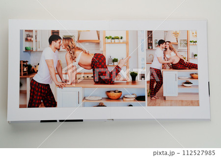 The pages of a photo book with color photos of a pregnant blonde and a man.  112527985