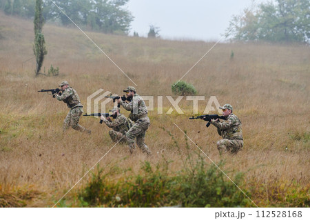 A disciplined and specialized military unit, donned in camouflage, strategically patrolling and maintaining control in a high-stakes environment, showcasing their precision, unity, and readiness for A disciplined and specialized military unit, donned in camouflage, strategically patrolling and maintaining control in a high-stakes environment, showcasing their precision, unity, and readiness for 112528168