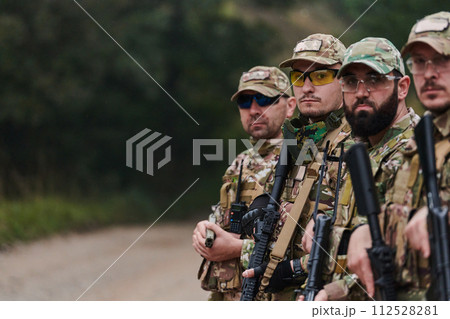 Soldier fighters standing together with guns. Group portrait of US army elite members, private military company servicemen, anti terrorist squad 112528281