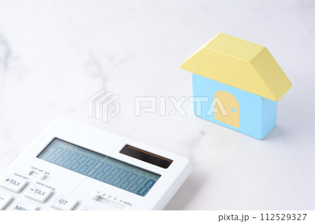 家と電卓で、あこがれのマイホームを購入しようとしているイメージ 112529327