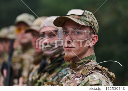 Soldier fighters standing together with guns. Group portrait of US army elite members, private military company servicemen, anti terrorist squad Soldier fighters standing together with guns. Group portrait of US army elite members, private military company servicemen, anti terrorist squad 112530348