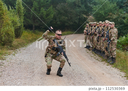 A major imparts precise military instructions to his elite unit, embodying strategic leadership as they gather for a briefing on tactical maneuvers and disciplined coordination 112530369