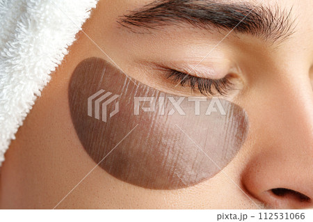 Portrait of attractive young male model with eye patches on white background Portrait of attractive young male model with eye patches on white background 112531066