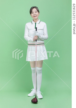 A senior woman holding a golf club A senior woman holding a golf club 112531629