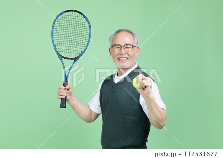 A senior man who plays tennis with a tennis racket 112531677