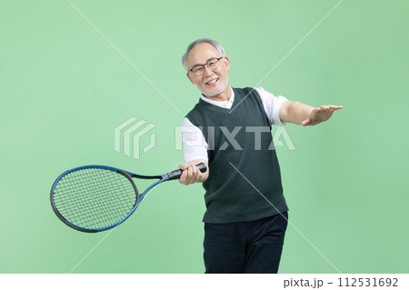 A senior man who plays tennis with a tennis racket 112531692