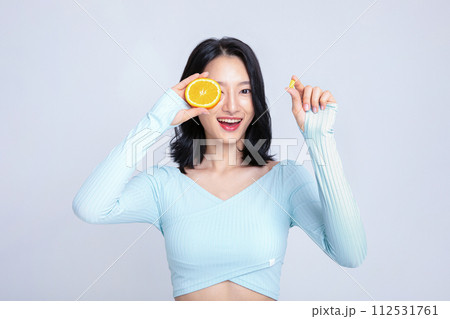 A woman holding a pill and an orange 112531761