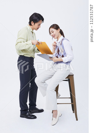A man and a woman talking to a tablet while filing 112531787