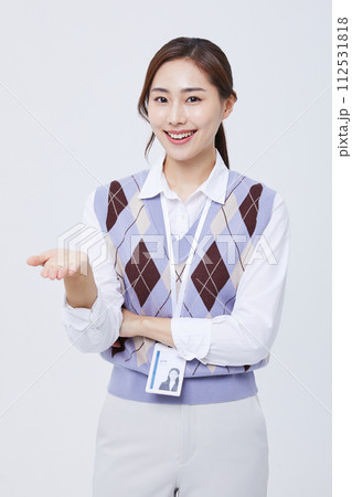 A woman who performs hand gestures with her employee ID around her neck 112531818