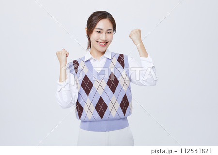A woman who clenches her employee ID around her neck and cheers with her fist 112531821