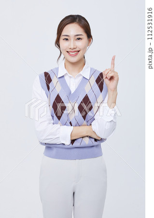 A woman who performs hand gestures with her employee ID around her neck 112531916
