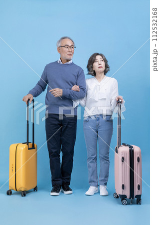 A senior standing with a travel suitcase A senior standing with a travel suitcase 112532168
