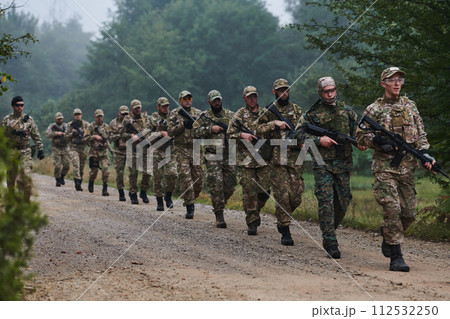 An elite military unit, led by a major, confidently parades through dense forest, showcasing precision, discipline, and readiness for high-risk operations 112532250
