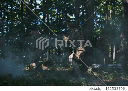 A specialized military antiterrorist unit conducts a covert operation in dense, hazardous woodland, demonstrating precision, discipline, and strategic readiness 112532306