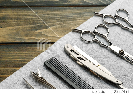 Hairdressing professional scissors on wooden background close up Hairdressing professional scissors on wooden background close up 112532451