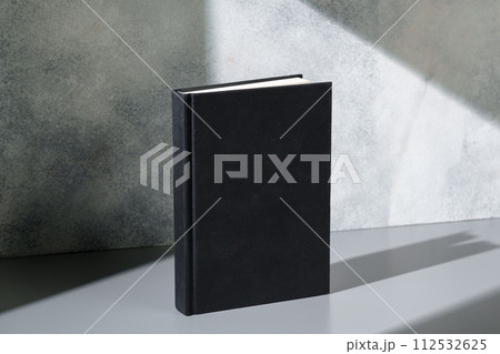 Black notepad with hard cover on gray background 112532625