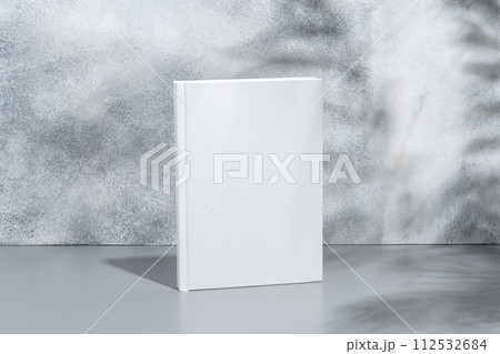White blank book with hard cover on gray background with shadows 112532684