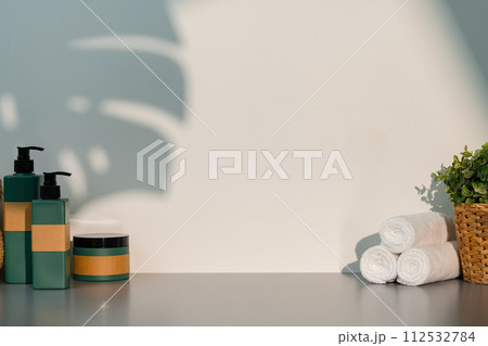 Soap dispenser and spa towels on white background in shadow 112532784
